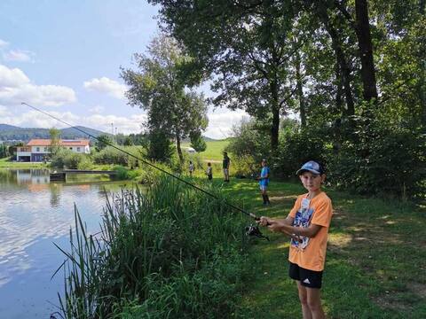 Junge mit Angelrute am Ufer des Furthweihers an einem Sommertag